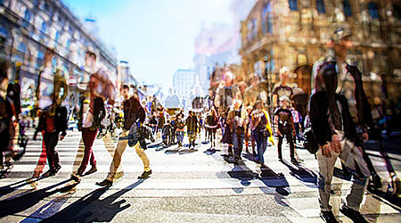 Crowd of anonymous people walking on busy city street